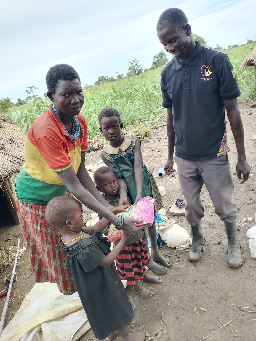 Team members walking through a distributed community maize field with farmers and children