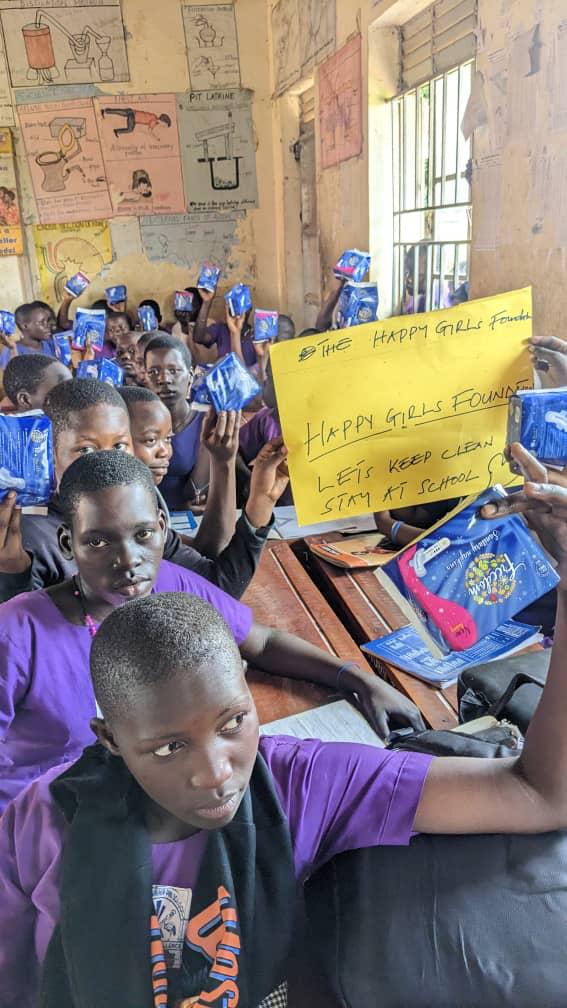 Girls displaying sanitary pads during the Happy Girls Club session — 'Let's Keep Clean, Stay at School'