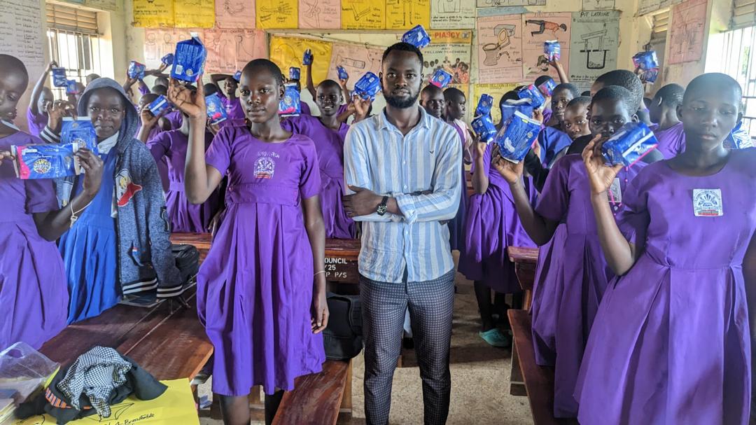 Pupils holding up donated sanitary pads in class