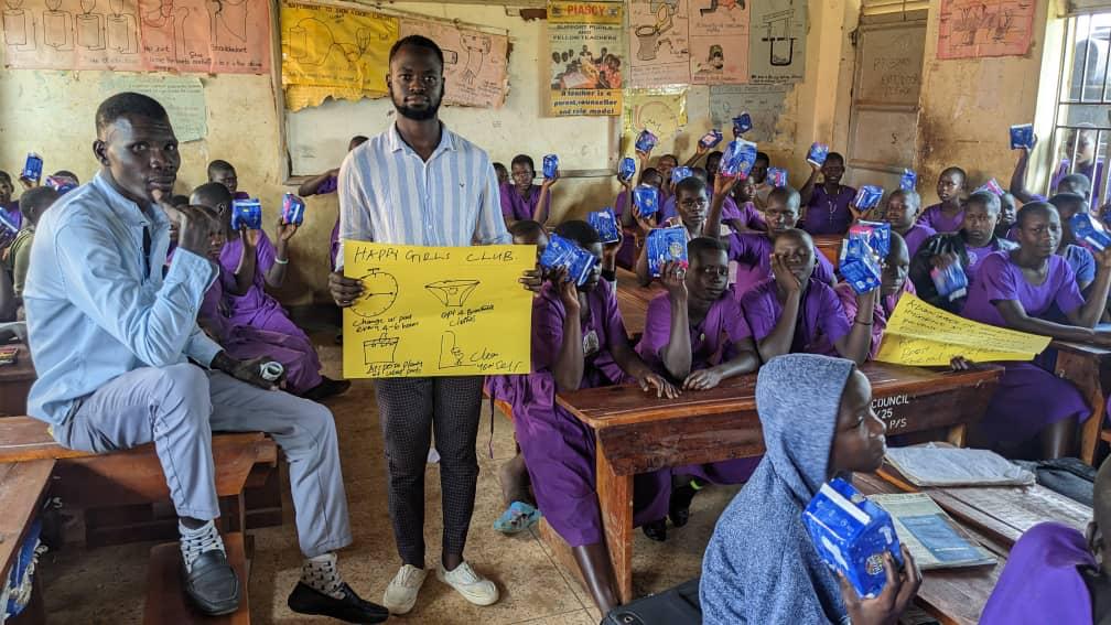 Pupils cheerfully showing their received sanitary pads during school distribution