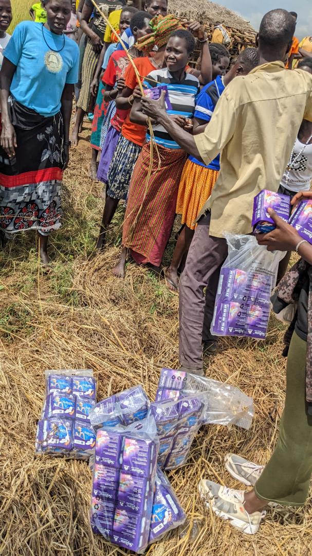 Women from the Karamoja community holding their received sanitary pads with gratitude