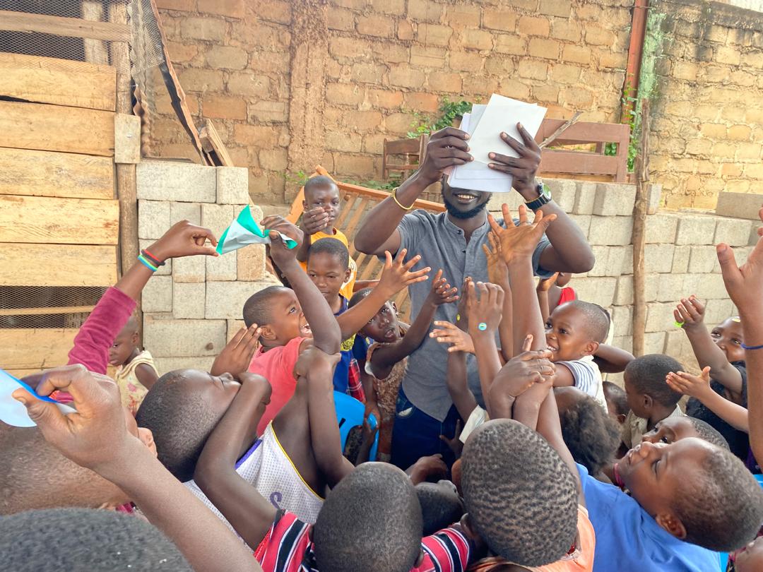 Children eagerly receiving their exercise books and stationery during distribution