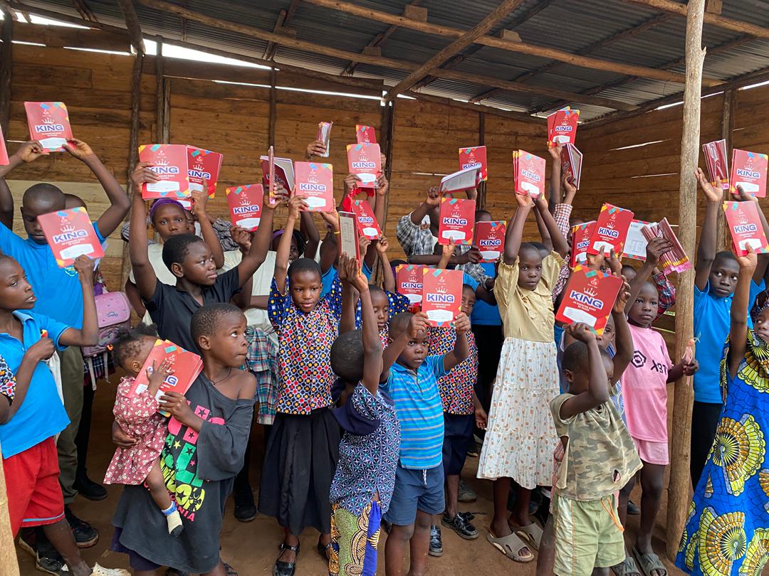 Children in Banda slum holding up their newly received KING exercise books